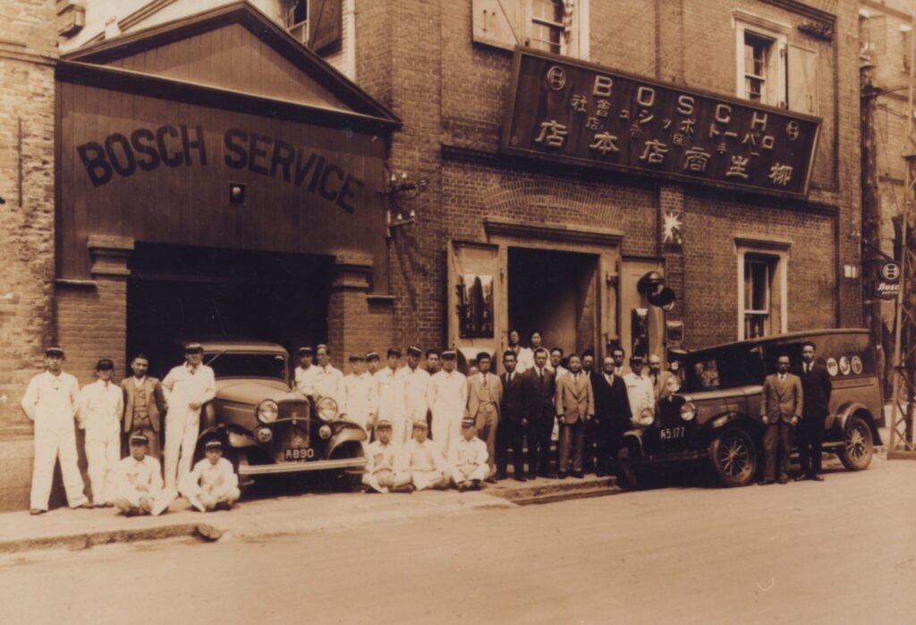 Manager and employees of Bosch Dept. Kobe and Yagyu Shoten LTD Kobe in 1920’s 神戸イリス商会ボッシュ部と柳生商店本店前のマネージャーと従業員 (1920年代)