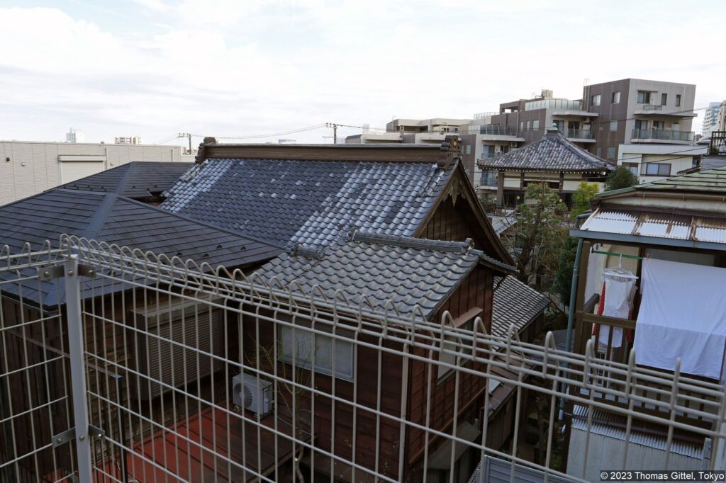 Haramachi 3-chōme: Blick über ein Meer von Dächern, Tempeln und kleinen Einfamilienhäusern. Nur wenige 10 Meter hinter der ersten Häuserreihe fällt das Gelände um mehrere Meter ab.