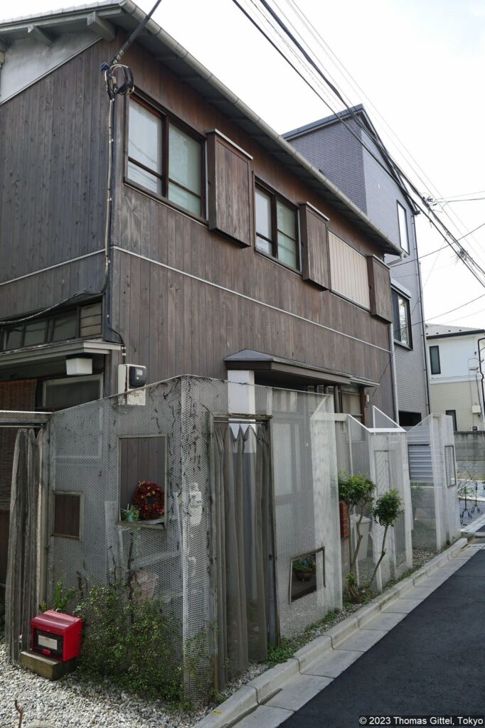 Traditionell-moderne Wohnbesiedlung in Yaraichō mit raffinierter "Zaunlösung" und einem Vorhang aus Metallketten statt eines Tors.